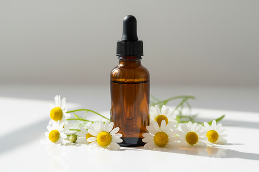 Frasco con extracto de manzanilla ámbar oscuro y flores blancas